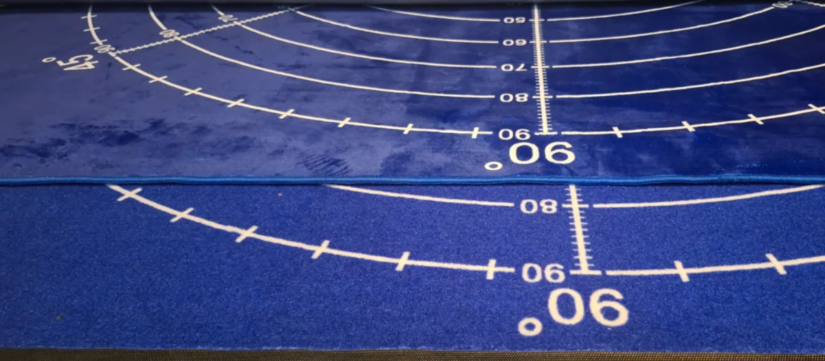 Blue printed testing mat with angle lines and distance arcs printed in white