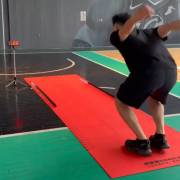 Athlete preparing to jump on the long jump mat on a court