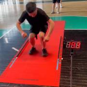 Athlete landing on the mat with the display beside it
