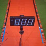 Timer display on a tripod at the end of the orange long jump mat