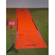 Long jump mat rolled out on turf with the display