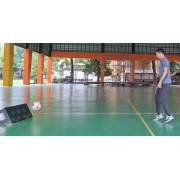 Player passing a ball into the dimpled rebound board on an outdoor covered court