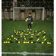 Young goalkeeper standing behind the 2.8 x 2 m rebound net in front of a full size goal