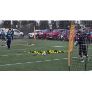 Goalkeepers training with the rebound net laid in front of a portable goal