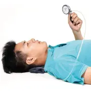 Pad under the neck while lying on the back, with the gauge held up to read